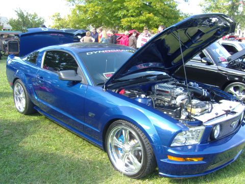 2007 Ford Mustang - Blue 2007 Ford Mustang GT at a car show, hood open to reveal a supercharger.