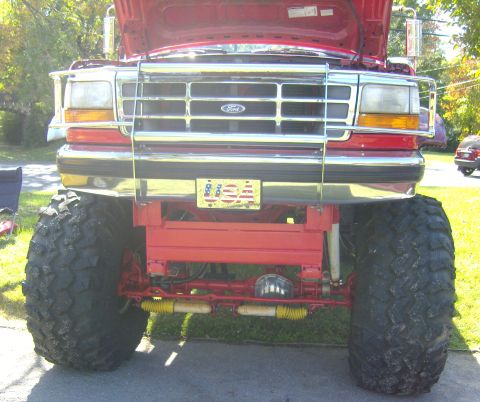 2007 Ford Mustang - This lifted truck features a prominent chrome grille and oversized tires, with a 'USA' license plate visible.