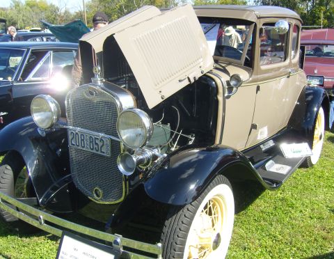 2007 Ford Mustang - A vintage Ford Model A coupe is displayed with its hood open at an outdoor event.