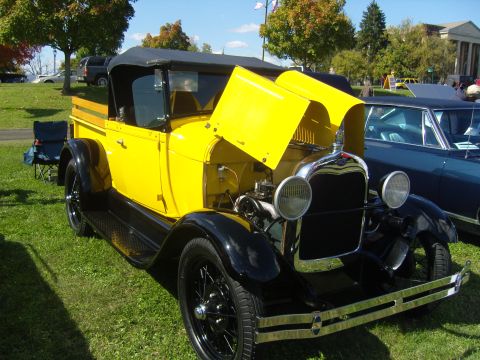 2007 Ford Mustang - A classic yellow pickup truck with its hood open is displayed on a grassy lawn.