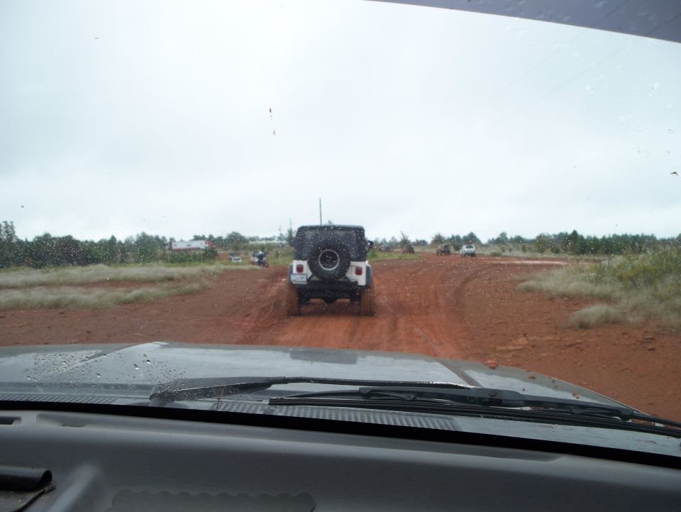 Rear view of white Jeep Wrangler on dirt road