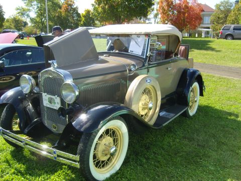 2007 Ford Mustang - This classic Ford Model A convertible is displayed outdoors on a grassy field with trees in the background.