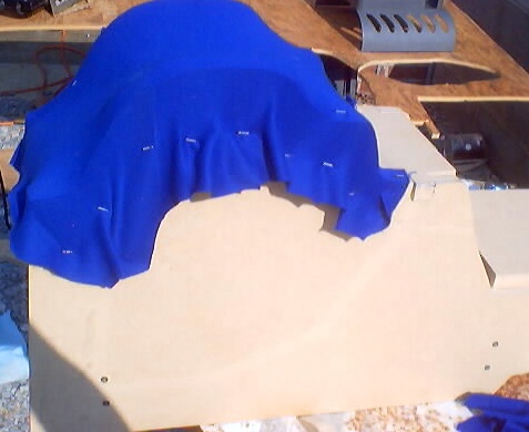 1999 Ford Taurus - A vehicle is partially covered by a blue tarp, obscuring its details.