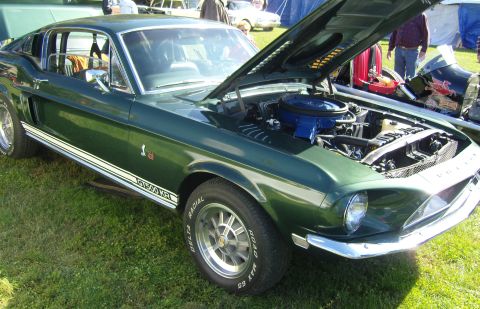 2007 Ford Mustang - A classic green 1968 Shelby GT500 KR Mustang is displayed with its hood open, revealing the engine.