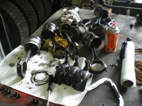 1974 Ford Ranchero - Disassembled engine components, including pistons and connecting rods, are laid out on a workbench, suggesting a repair or rebuild process.