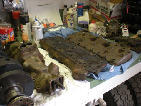 1974 Ford Ranchero - Engine parts including a block, crankshaft, and cylinder heads are laid out on a workbench.