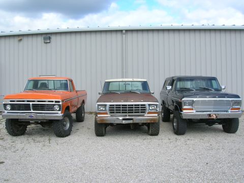 1975 Ford F-250 - Three Ford trucks from the 1970s are parked in front of a building.
