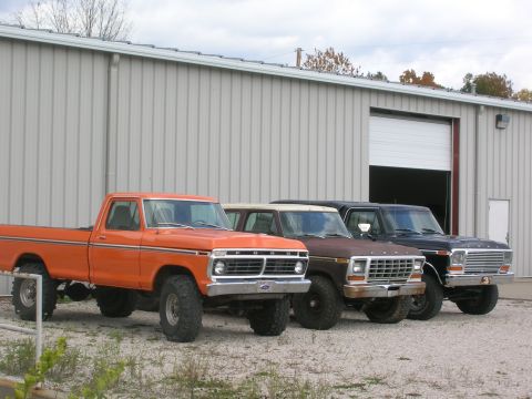 1975 Ford F-250 - Three Ford F-Series trucks from the 1970s are parked outside a warehouse.