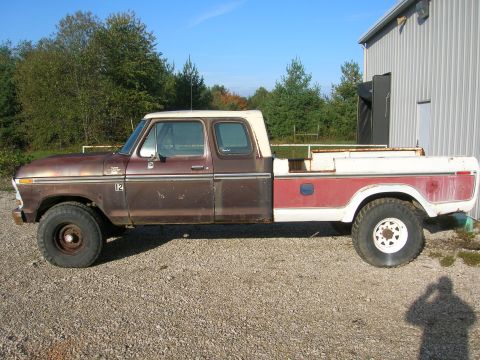 1975 Ford F-250 - This 1973 Ford F-250 pickup truck is seen from the side, parked on a gravel lot next to a building.