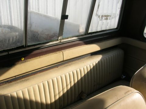 1975 Ford F-250 - Interior view of a truck cab, showing the bench seat and dirty windows.