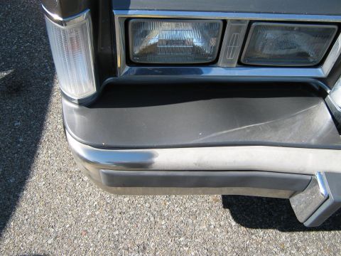 2000 Mercury Grand Marquis - Close-up of a sedan's front end, revealing its chrome bumper and headlight assembly.