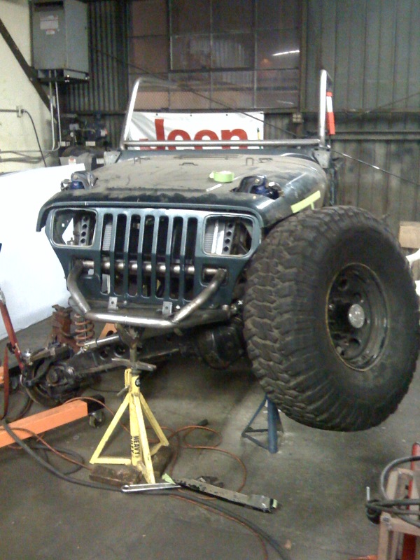 Jeep Wrangler front end on jack stands, large tire visible