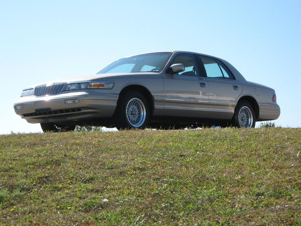 Tan 2000 Mercury Grand Marquis parked on a grassy hill