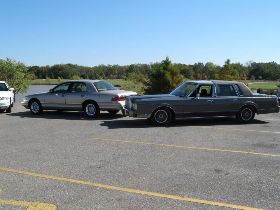 Gray Lincoln Town Car and silver Mercury sedan parked side-by-side