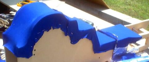 1999 Ford Taurus - A blue fabric covering is being shaped over a form, with a website logo visible in the corner.