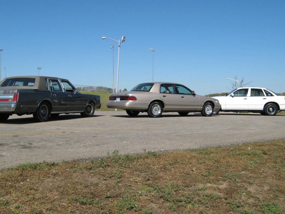 Lincoln Town Car, Mercury Grand Marquis, and a white sedan parked side-by-side