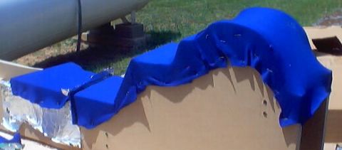 1999 Ford Taurus - Sections of a car seat upholstered in blue fabric are shown on a cardboard base, with a SuperMotors logo visible.