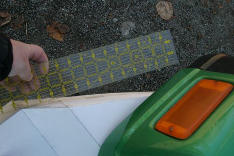 1987 Suzuki Samurai - A ruler is used to measure a surface next to a green vehicle component with an amber light.