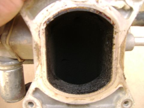 1998 Ford Crown Victoria - Close-up view of a dirty intake manifold port, likely from a vehicle requiring maintenance.