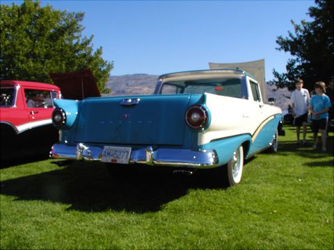 1967 Ford Ranchero - A classic two-tone Ford pickup truck is parked on a grassy lawn under a clear blue sky.