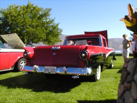1967 Ford Ranchero - A two-tone pickup truck with its hood open sits on a grassy lawn next to another vehicle.