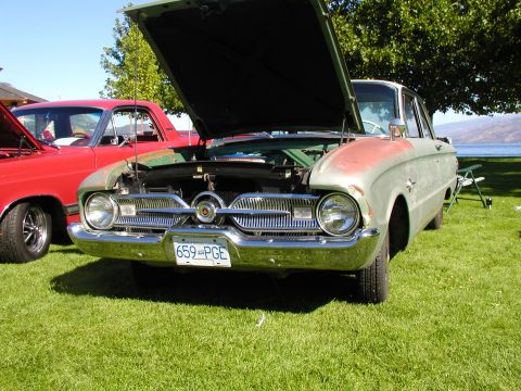 1967 Ford Ranchero - A vintage Ford Falcon with its hood up sits on a grassy lawn near a body of water, with another vehicle beside it.