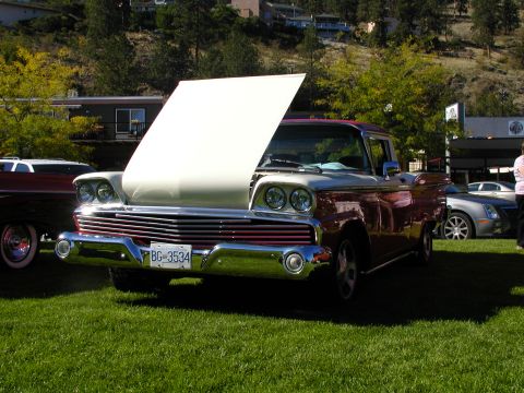 1967 Ford Ranchero - A two-tone 1957 Ford Fairlane 500 Skyliner is displayed with its hood open, parked on grass next to another vehicle.