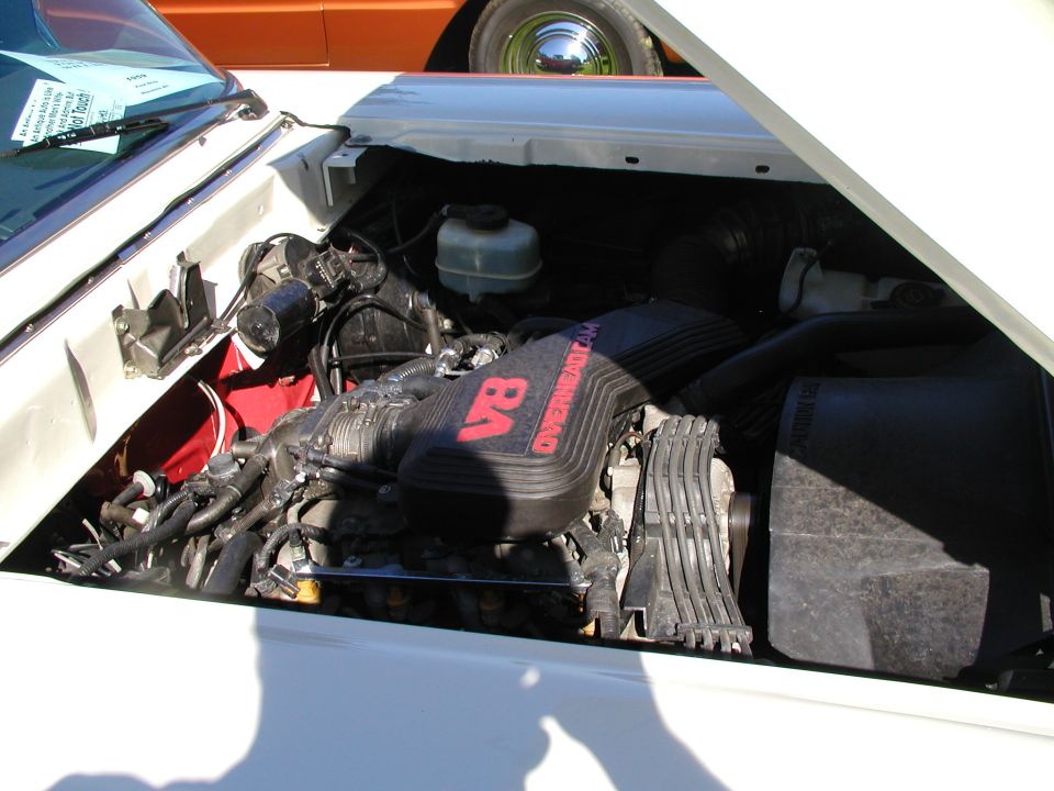Overhead-cam V8 engine swap in a white car's engine bay with black intake cover