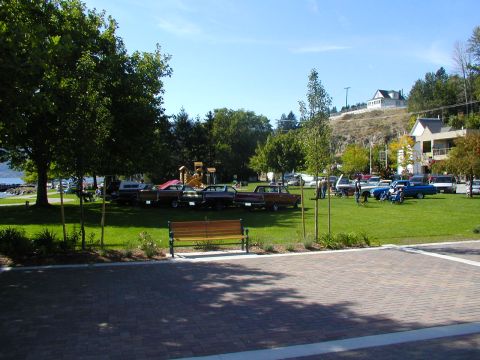 1967 Ford Ranchero - A collection of classic cars, including a 1967 Ford Ranchero, are displayed on a sunny day at a park event.