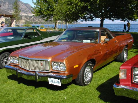 1967 Ford Ranchero - This 1977 Ford Ranchero, flame decals and chrome wheels, is parked on a grassy area near a body of water.