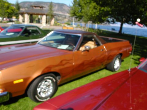 1967 Ford Ranchero - A copper 1977 Ford Ranchero with flame decals is parked on grass next to other vehicles.