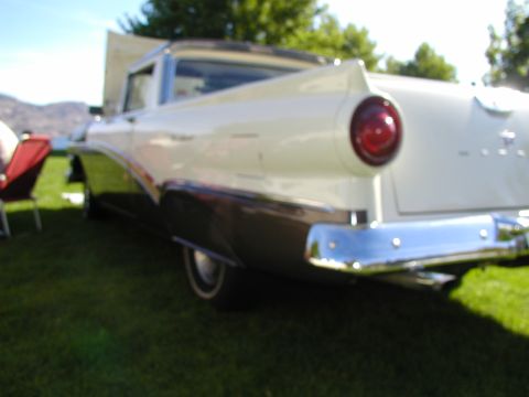 1967 Ford Ranchero - Two-tone classic car with a prominent round taillight and chrome bumper parked on grass.
