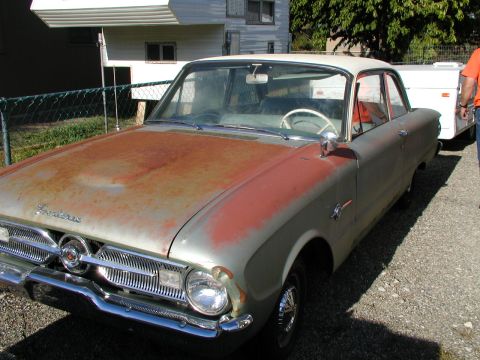 1967 Ford Ranchero - This weathered Ford Falcon shows significant rust on its hood and front end, with a white roof and interior visible.