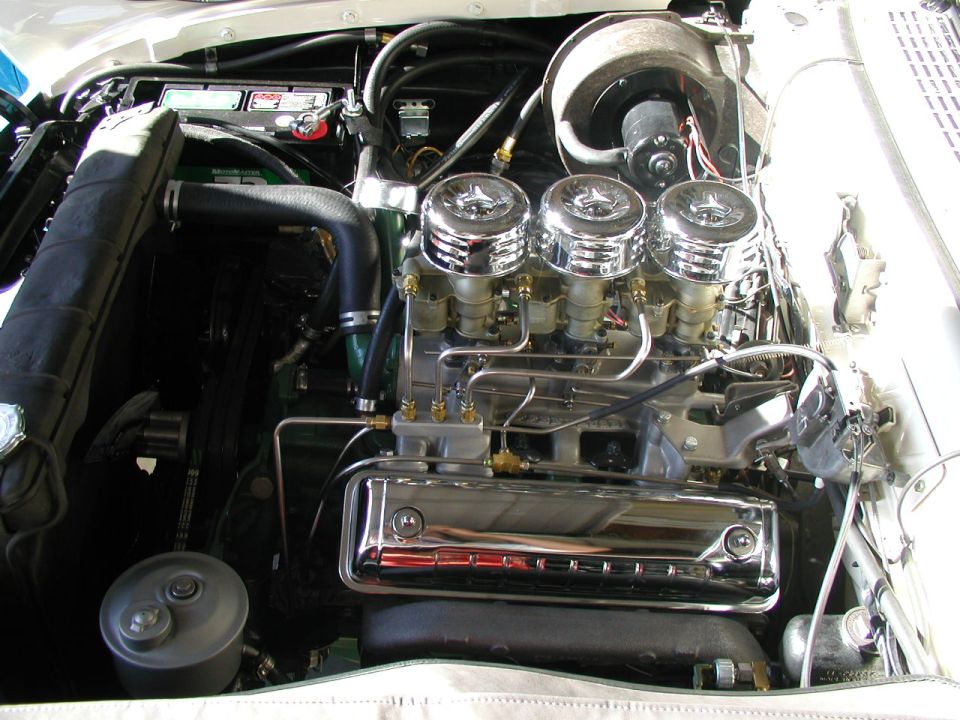Inline-six with three chrome-topped carbs and chrome valve cover in a white classic