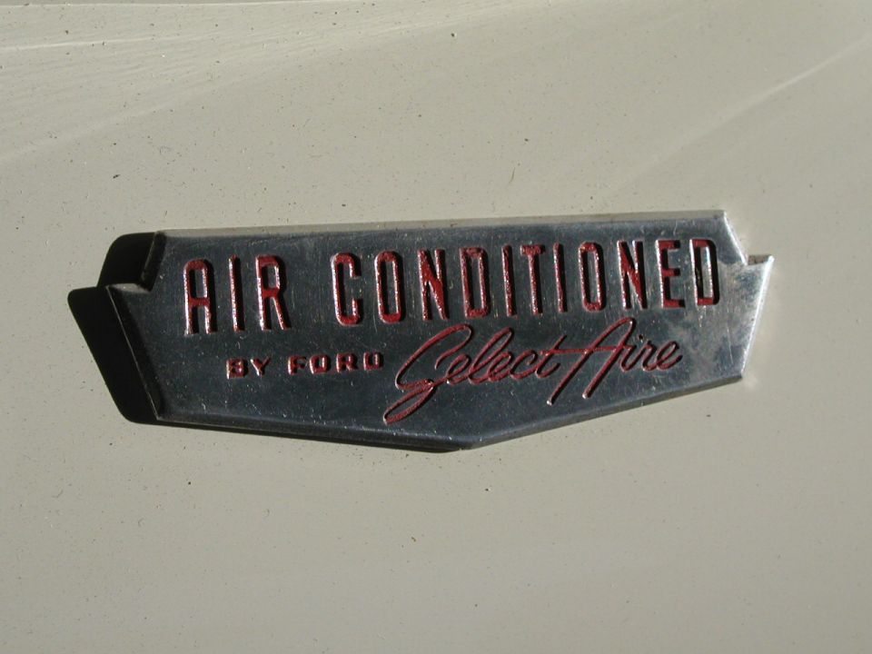 Chrome Ford Select-Aire "Air Conditioned" emblem with red lettering on white paint
