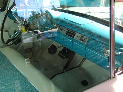 1967 Ford Ranchero - The turquoise dashboard and light green interior of a classic car are visible through the window.