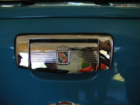 1967 Ford Ranchero - A chrome emblem with a shield and cross design is visible on the blue exterior of a vehicle.