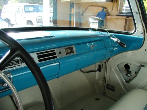 1967 Ford Ranchero - The dashboard features a turquoise finish and a prominent clock, with another vehicle visible outside.