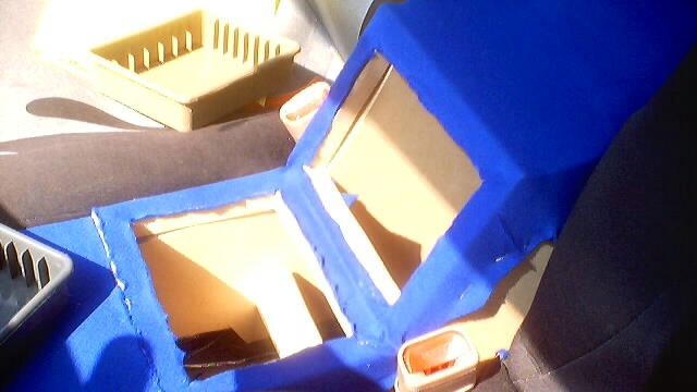 Custom blue upholstered center console with cutouts for storage or electronics