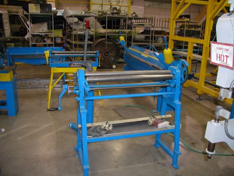 1967 Ford Ranchero - Workshop scene with industrial metal rolling machines and a caution sign.