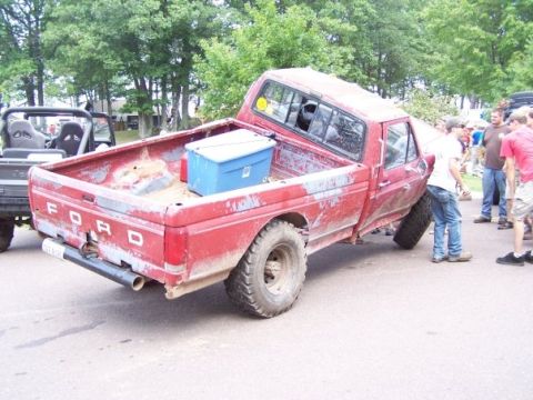 1989 Ford F-150 - Red Ford pickup truck with a blue toolbox in the bed, parked outdoors with trees in the background.