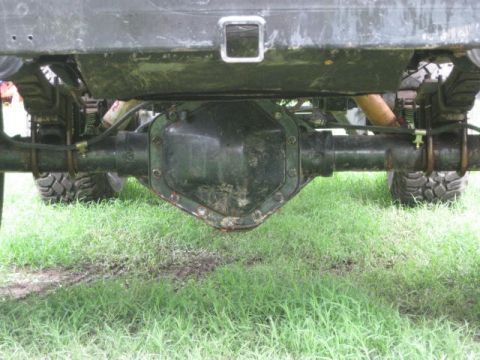 1973 Ford Bronco - Underside view of a vehicle's rear axle and suspension system, showing leaf springs and a differential housing.