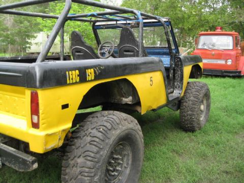 1973 Ford Bronco - This modified 1973 Ford Bronco features a roll cage, off-road tires, and custom paint with visible lettering.