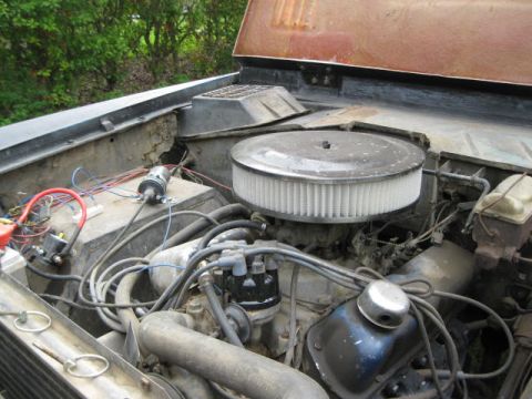 1973 Ford Bronco - The engine bay of a 1973 Ford Bronco, showing the air cleaner, distributor, and various hoses.