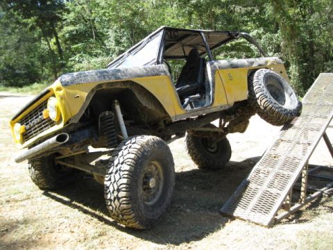 1973 Ford Bronco - This modified vehicle is positioned on an incline ramp, with its spare tire prominently displayed on the side.