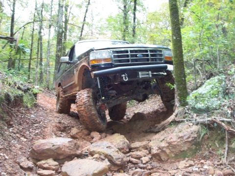 1995 Ford Bronco - This 1995 Ford Bronco tackles a challenging rocky incline on a wooded trail.