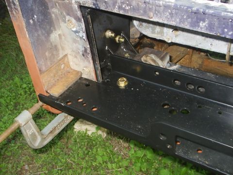 1984 Ford Bronco - Close-up of a brush guard or winch mount bracket being installed, secured with bolts and a C-clamp.
