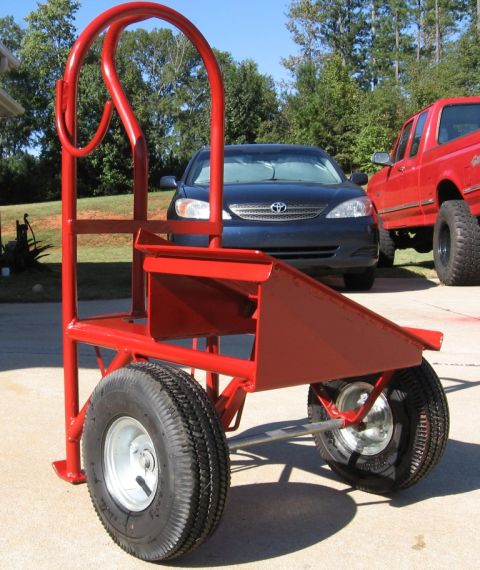1995 Ford F-150 - A red welding cart is in the foreground, with a blue sedan and a red pickup truck visible in the background.