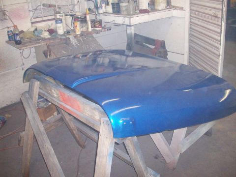 1978 Jeep CJ5 - Car hood undergoing repair or painting in a workshop setting.