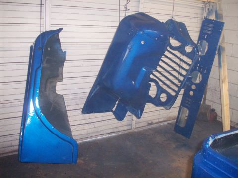 1978 Jeep CJ5 - Several blue Jeep CJ body panels are suspended, possibly after being painted.